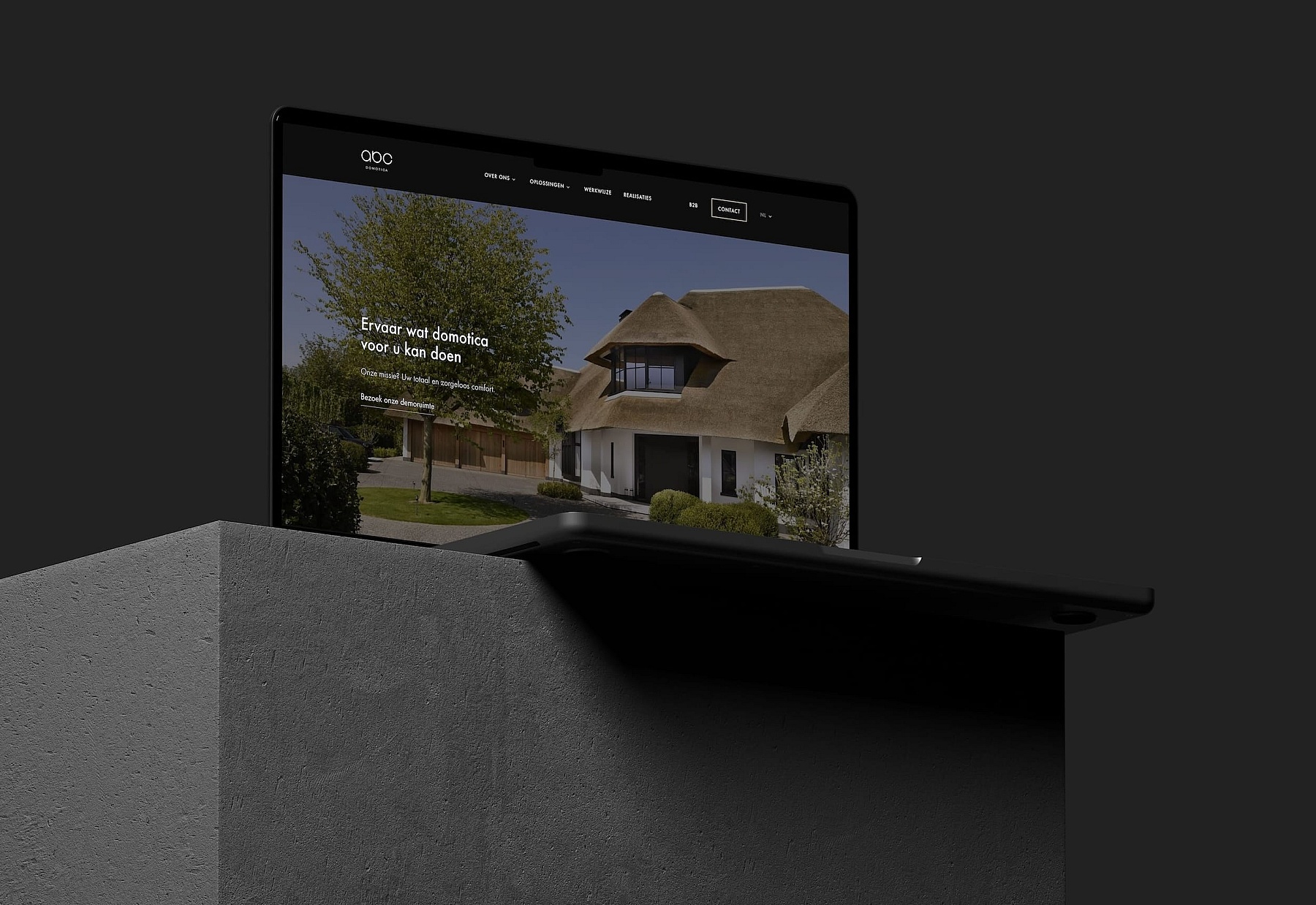 ABC Home automation&#039;s website open on a laptop sitting on a block of cement.