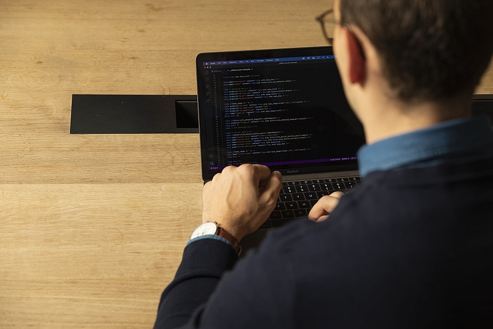 Maarten, a professional web designer from Antwerpen, is coding a website on his laptop from scratch